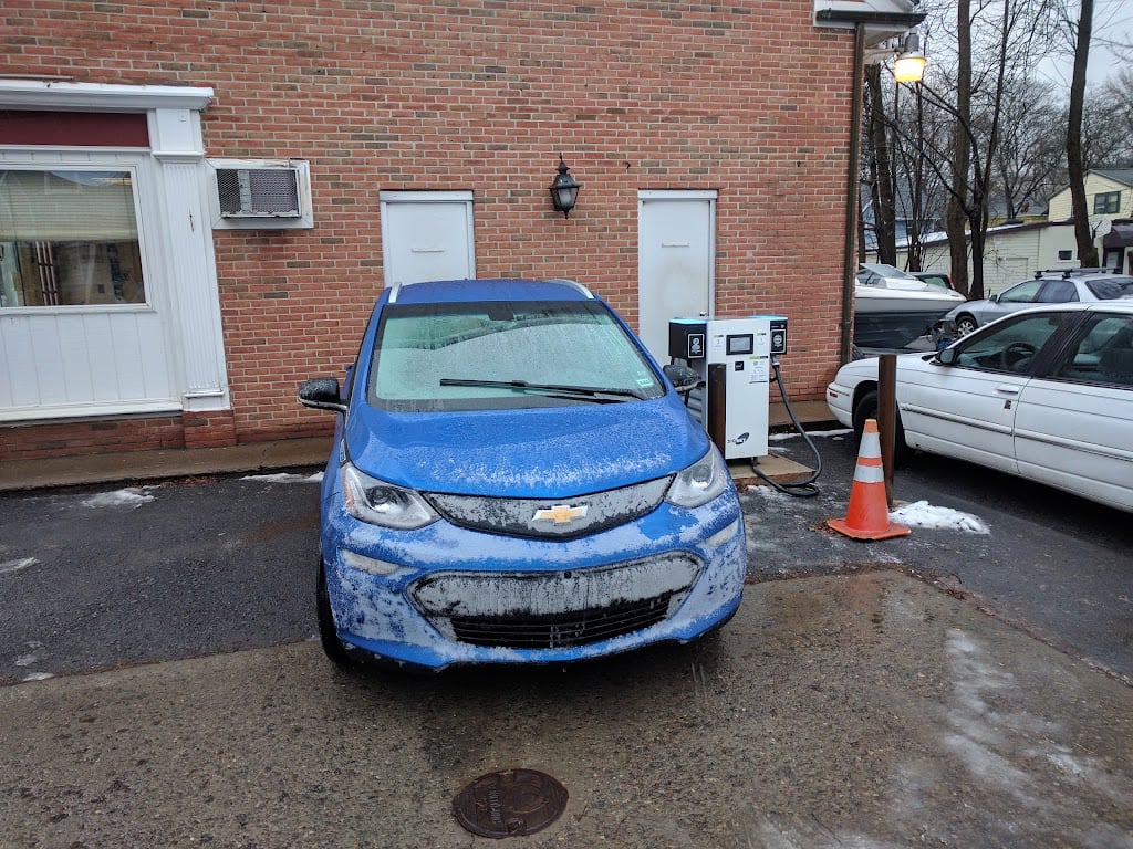 Blue electric vehicle parked beside the charging station at the shop